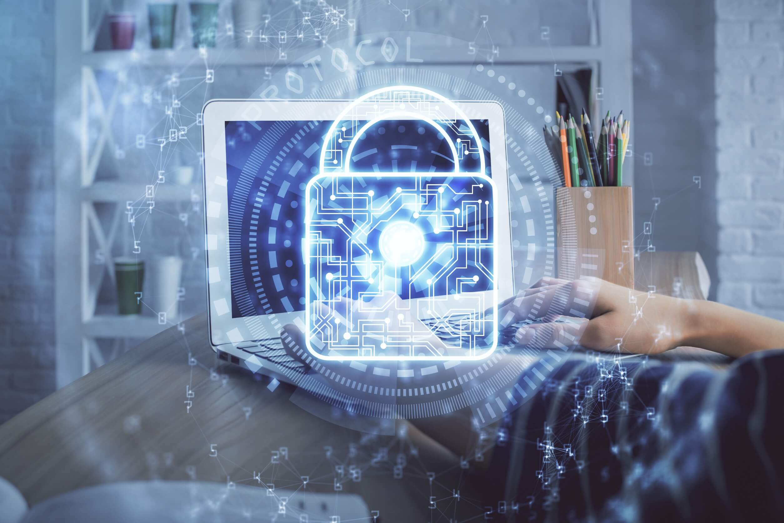 A person works on a laptop with a padlock icon displayed on the screen.